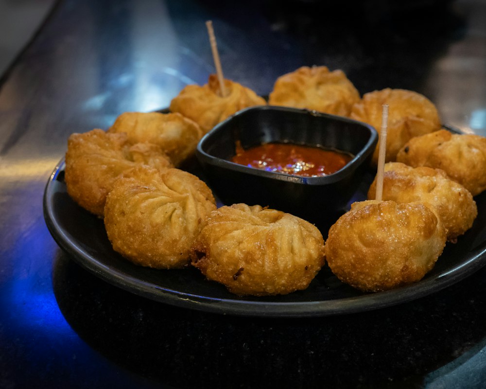 Fried momos around a bowl of chilli sauce