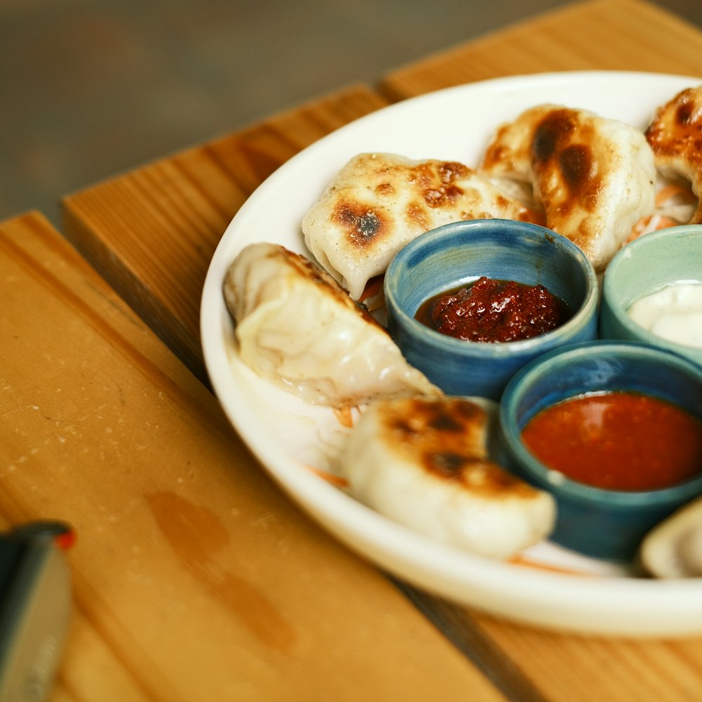 A plate of momos with dipping sauces